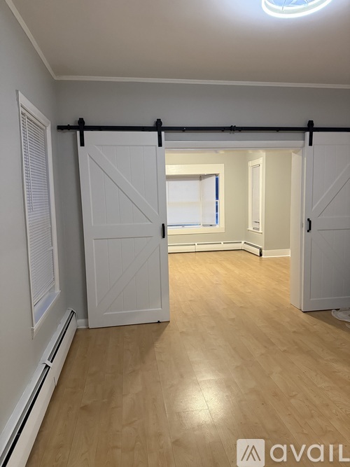 A room with a sliding door and wooden flooring.