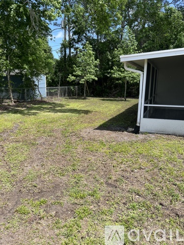 A white house with a yard in front of it.
