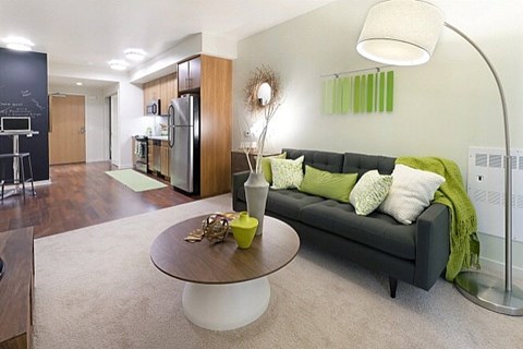 A modern living room with a black couch and a coffee table.