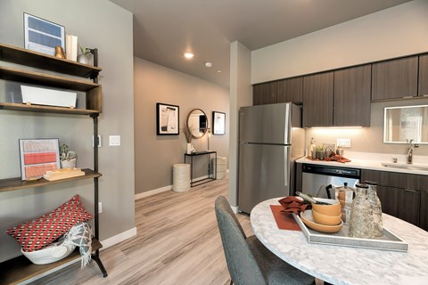 A modern kitchen with a dining table set for two.