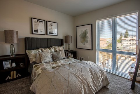 A bedroom with a large bed and a view of the city.