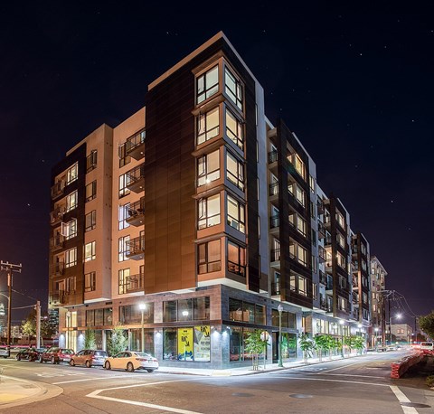 A modern apartment building with cars parked in front.