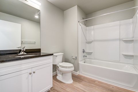 A white bathroom with a toilet, sink, and bathtub.