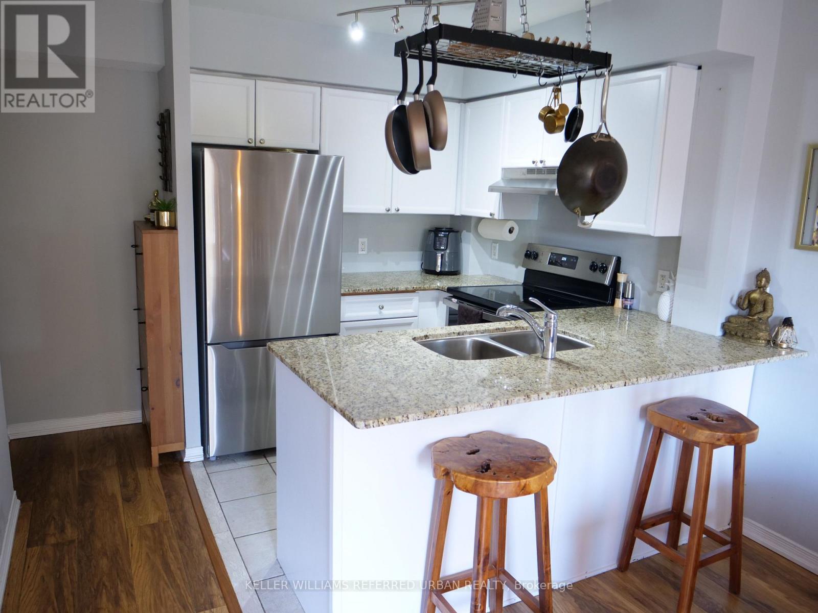 A kitchen with a granite countertop and a refrigerator.