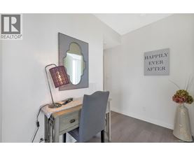 A desk with a chair and a mirror with a light on it.