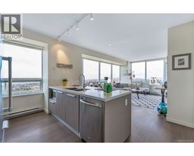 A modern kitchen with a large island and a view of the city.