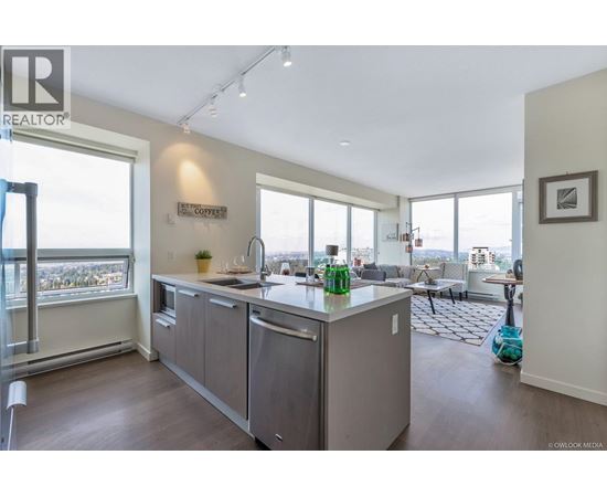 A modern kitchen with a large island and a view of the city.