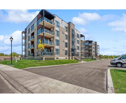 A modern apartment building with a parking lot in front.