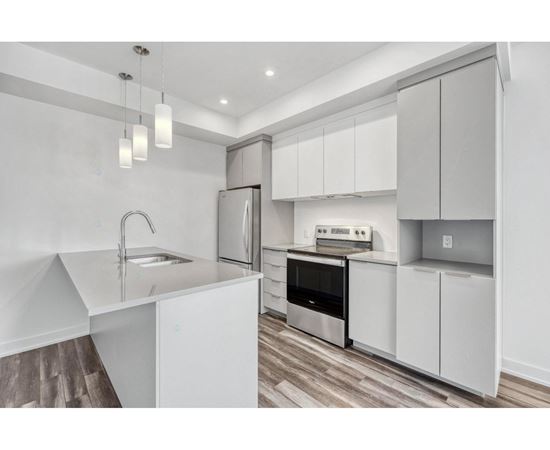 A modern kitchen with white cabinets and stainless steel appliances.