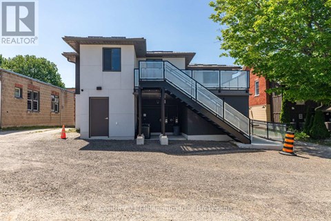 A modern house with a white exterior and a glass staircase leading to the entrance.