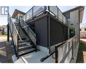 A staircase with a metal railing leads up to a building entrance.