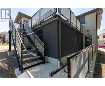 A staircase with a metal railing leads up to a building entrance.