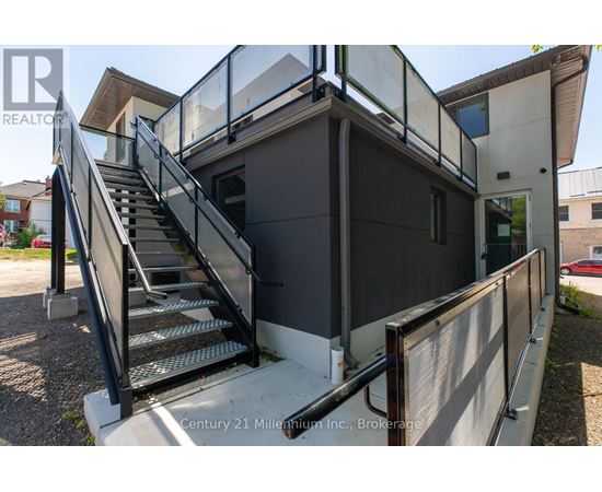 A staircase with a metal railing leads up to a building entrance.