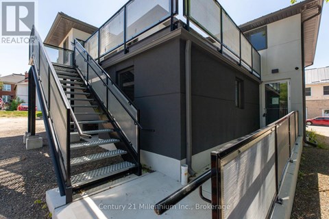 A staircase with a metal railing leads up to a building entrance.