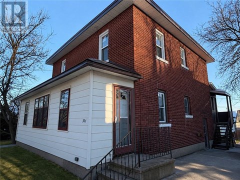 A red brick house with a white front porch.