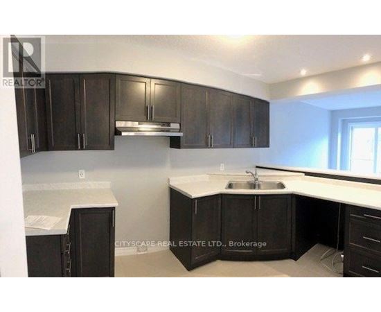 A kitchen with dark brown cabinets and a white countertop.