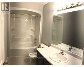 A white bathroom with a glass shower stall and a toilet.