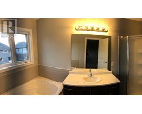 A bathroom with a sink, mirror, and a window.