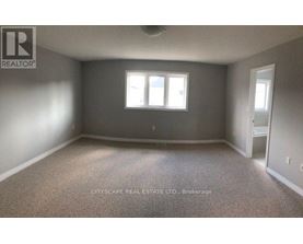 A room with a carpeted floor and a window.