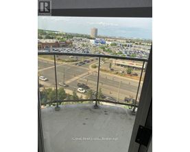 A view from a balcony looking out over a parking lot and buildings.