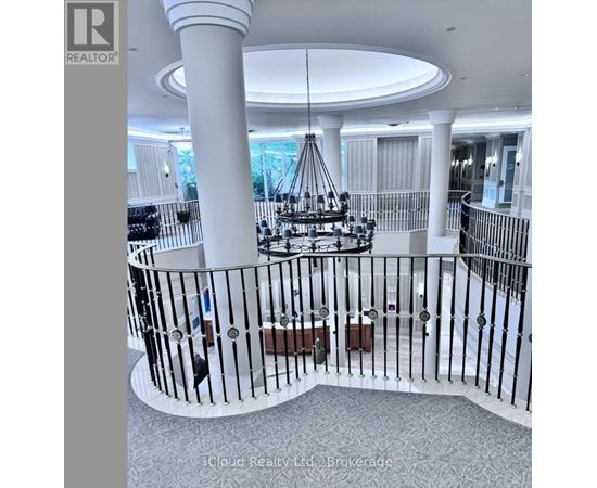 A large white column with a circular top and a black wrought iron railing.