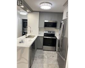 A modern kitchen with stainless steel appliances and a white countertop.