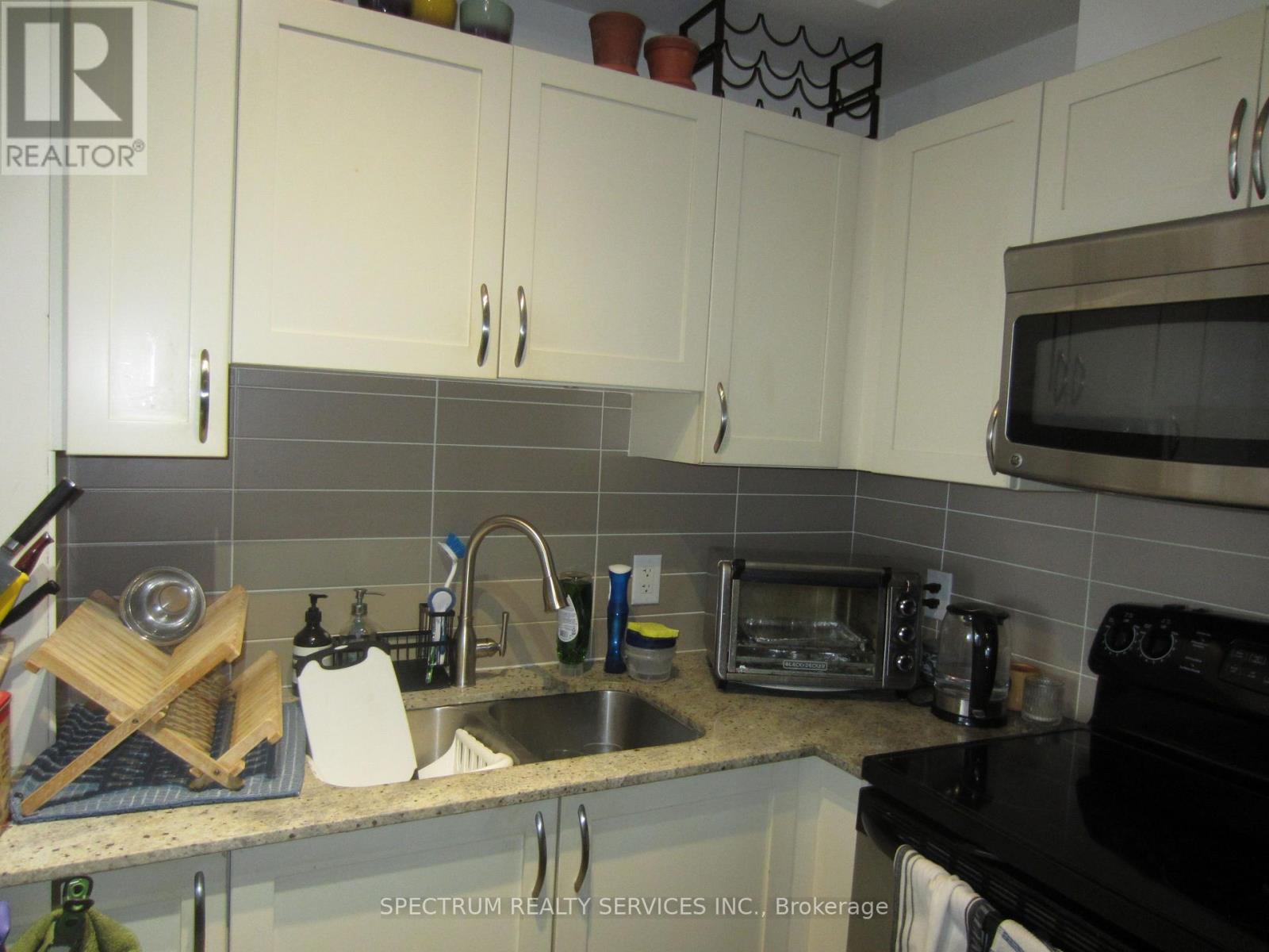 A kitchen with a black stove top oven and white cabinets.