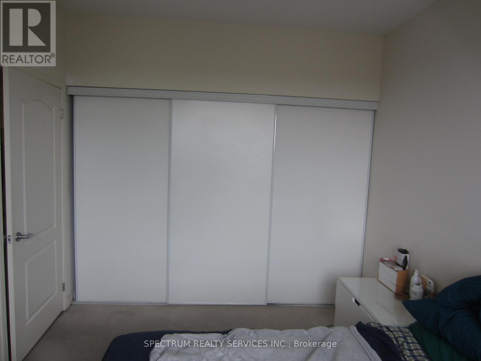 A white bedroom with a bed and a dresser.