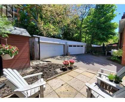 A backyard with a white chair and a flower bed.