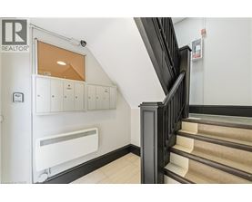 A staircase with a black railing and beige steps.