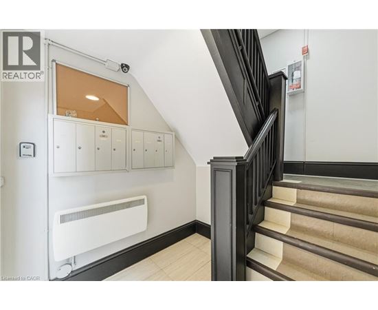 A staircase with a black railing and beige steps.