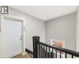 A room with a white door and a window with a black railing.