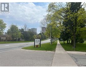 A street view with a sign that reads "10-20" and a logo for Bay Street Integrity Realty, Inc. Brokerage.