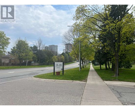 A street view with a sign that reads "10-20" and a logo for Bay Street Integrity Realty, Inc. Brokerage.