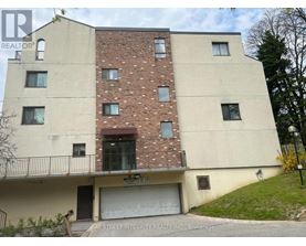 A two-story building with a garage door and a balcony.
