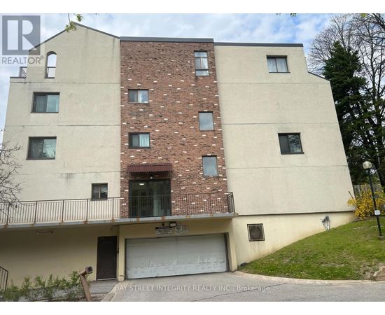 A two-story building with a garage door and a balcony.