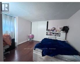 A bedroom with a bed, dresser, and window.