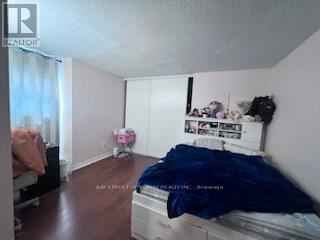 A bedroom with a bed, dresser, and window.