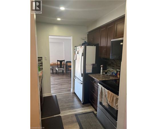 A kitchen with a black refrigerator and black oven.
