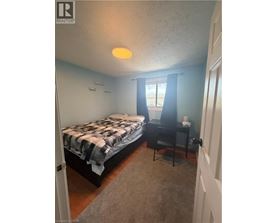 A bedroom with a bed and a desk.