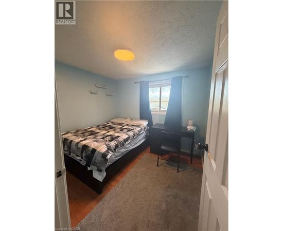 A bedroom with a bed and a desk.