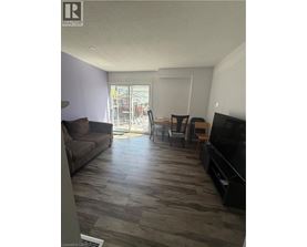 A living room with a couch, chairs, and a television.