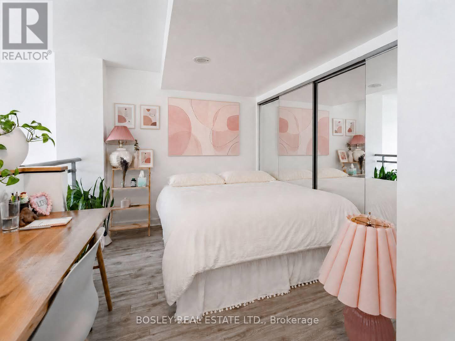 A bedroom with a bed, nightstand, and lamp.