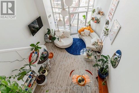 A living room with a white couch and a blue rug.