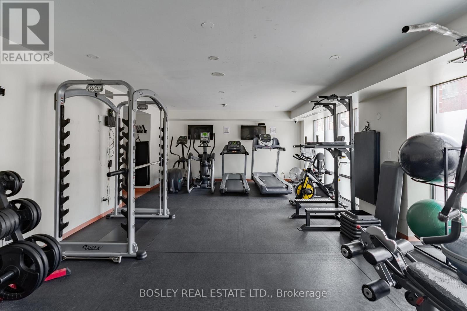 A gym with a variety of equipment including a treadmill, weights, and a bench press.