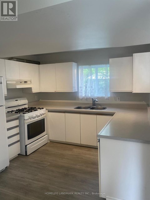 A kitchen with white cabinets and a stove top oven.
