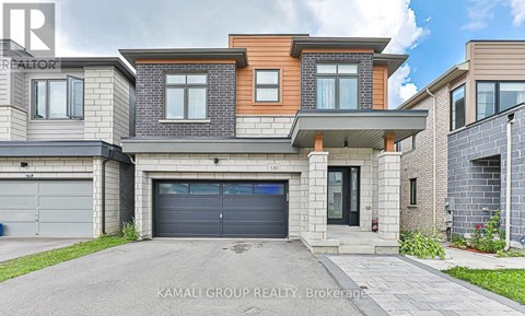 A modern two-story house with a garage is for sale by Kamali Group Realty Brokerage.