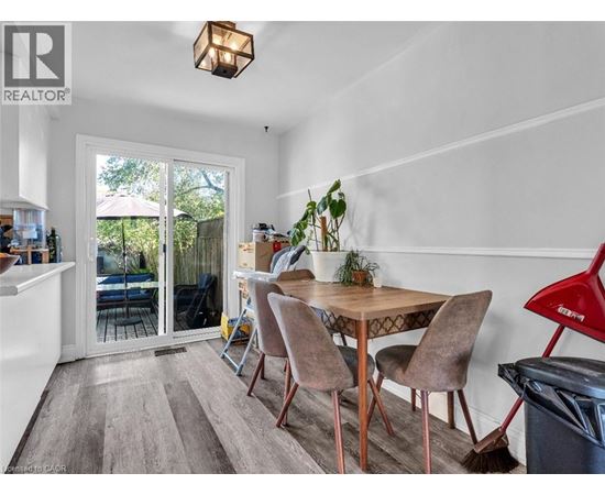 A dining room with a table and chairs and a broom.