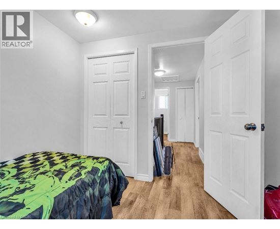 A bedroom with a bed and a suitcase on the floor.