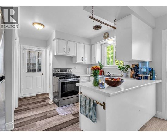 A kitchen with white cabinets and a wooden floor.